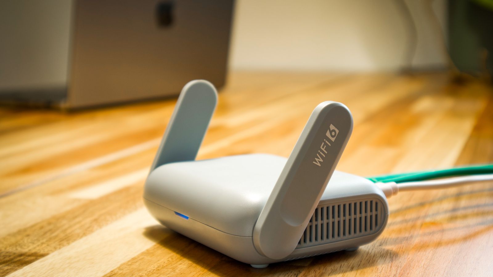 Box internet 5G Wi-Fi 6 posée sur un parquet clair, équipée d'un port RJ11 pour brancher un téléphone fixe