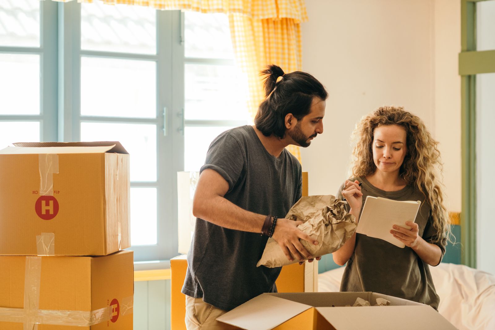 Un couple emménage dans son nouveau logement et coche sa checklist de déménagement, dont l'abonnement internet