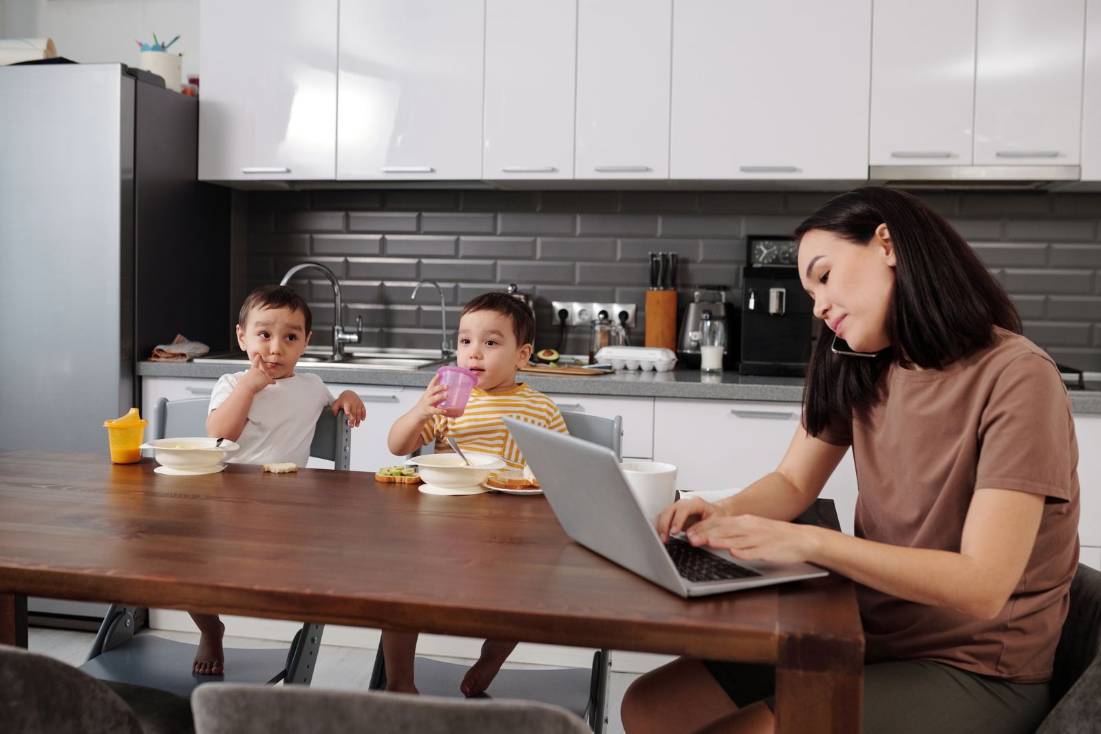 Parent consultant Pronote et l'ENT sur un ordinateur portable dans la cuisine familiale
