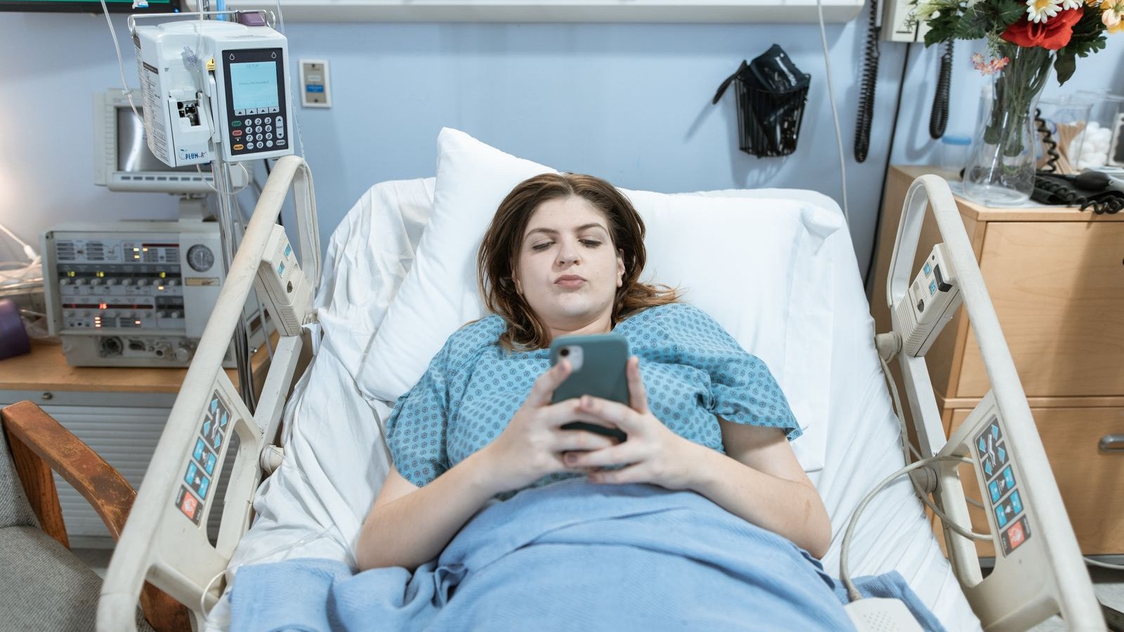Patiente dans un lit d'hôpital utilisant son smartphone connecté au Wi-Fi d'une box 5G