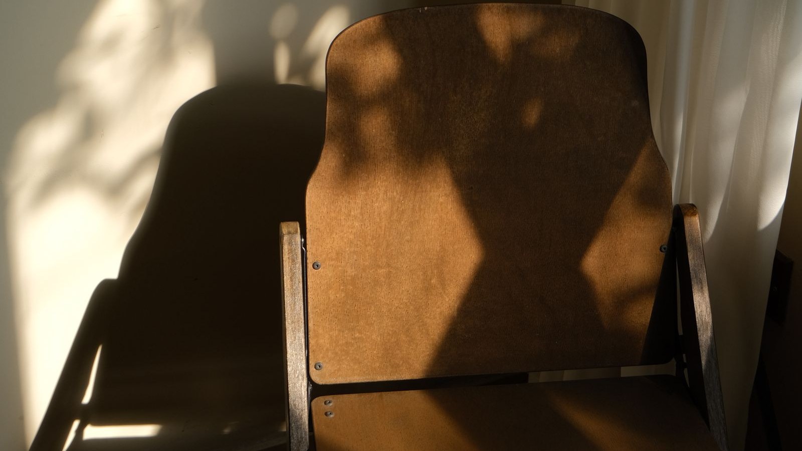 Chaise vide dans la lumière d'une maison familiale, le temps de la succession