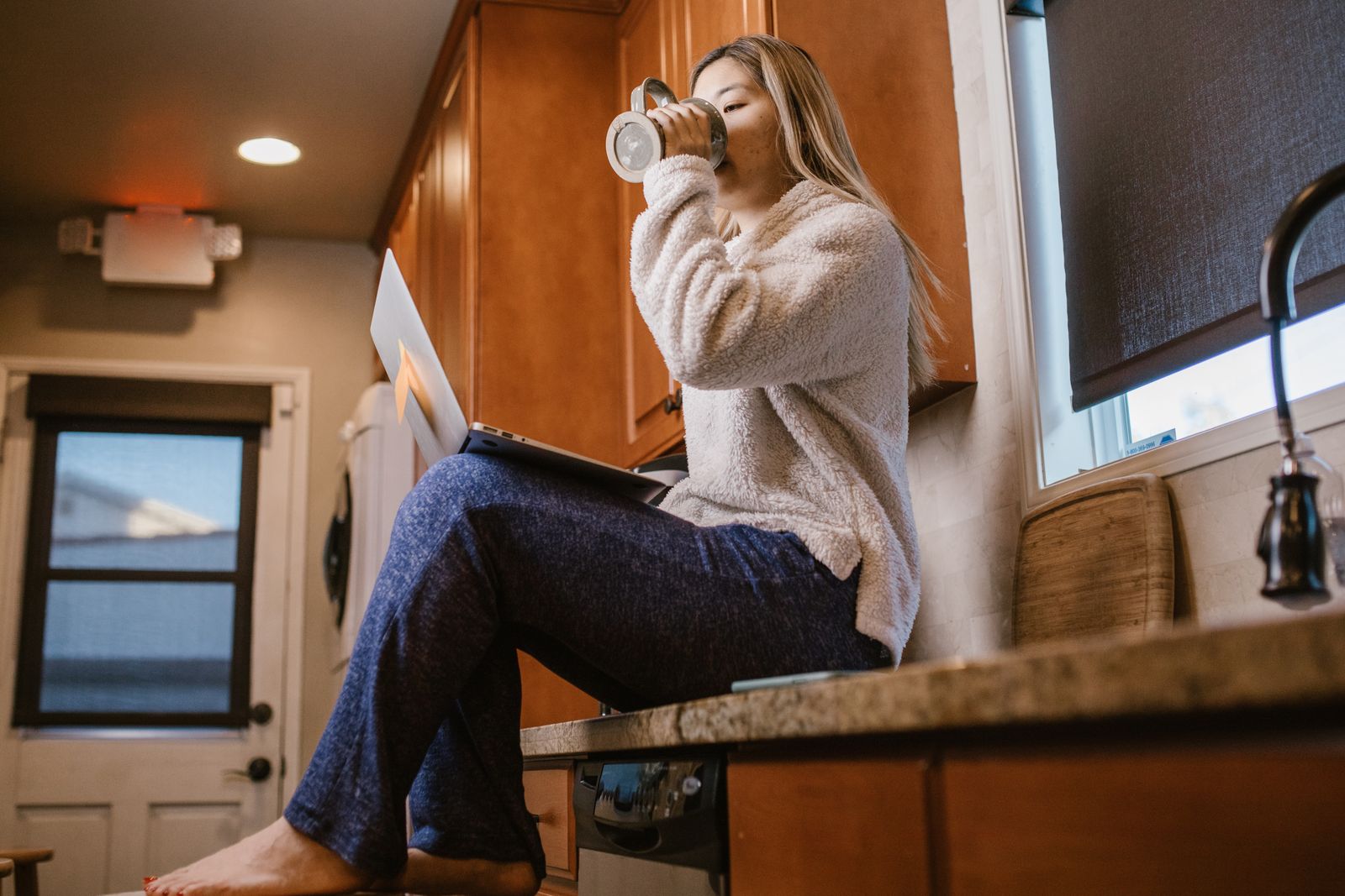 Une personne travaille tranquillement chez elle sur son ordinateur portable grâce à une connexion de secours en box 5G pendant une panne internet