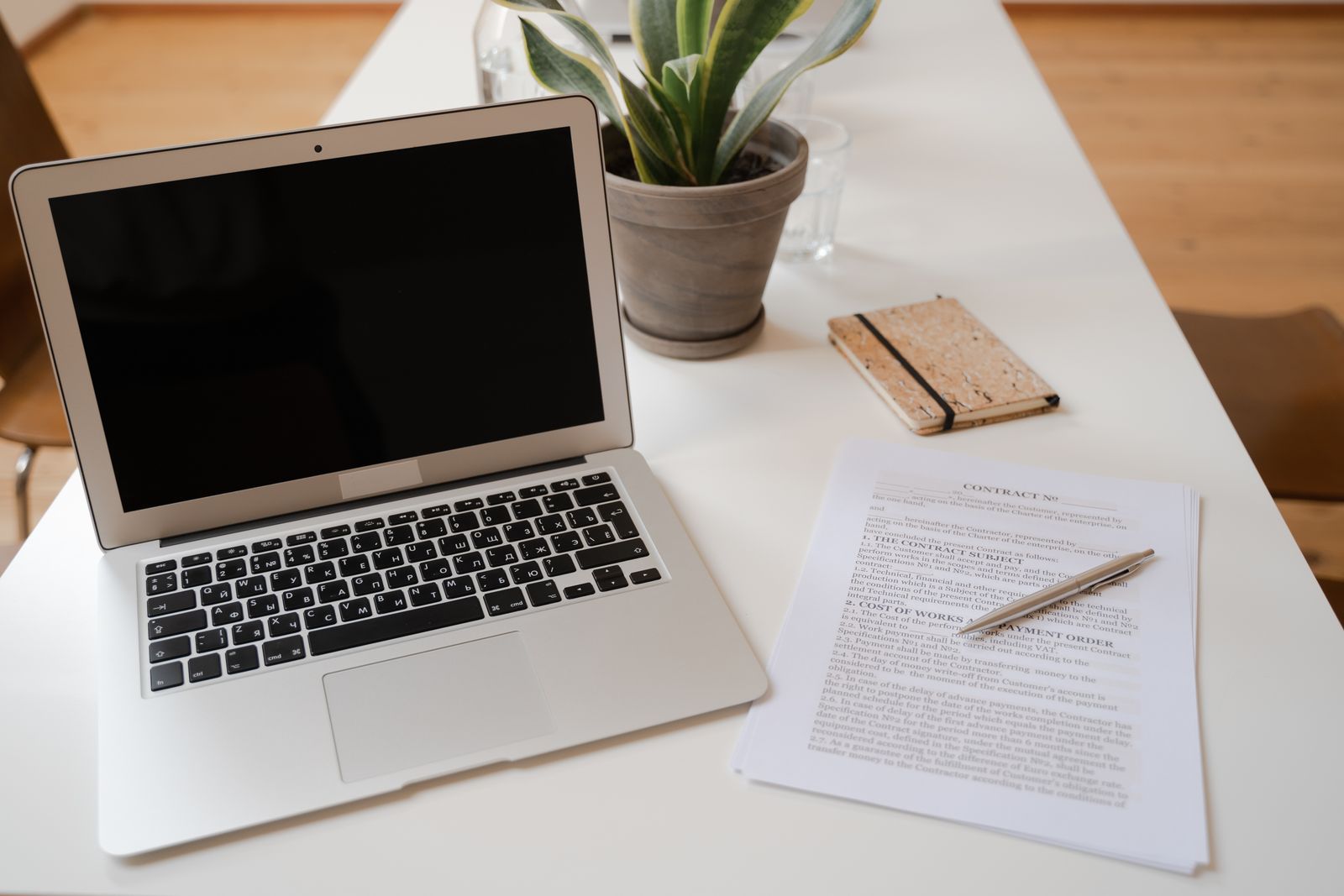 Ordinateur portable et conditions de vente posés sur une table en bois : vérifier les frais d'une box internet avant de commander