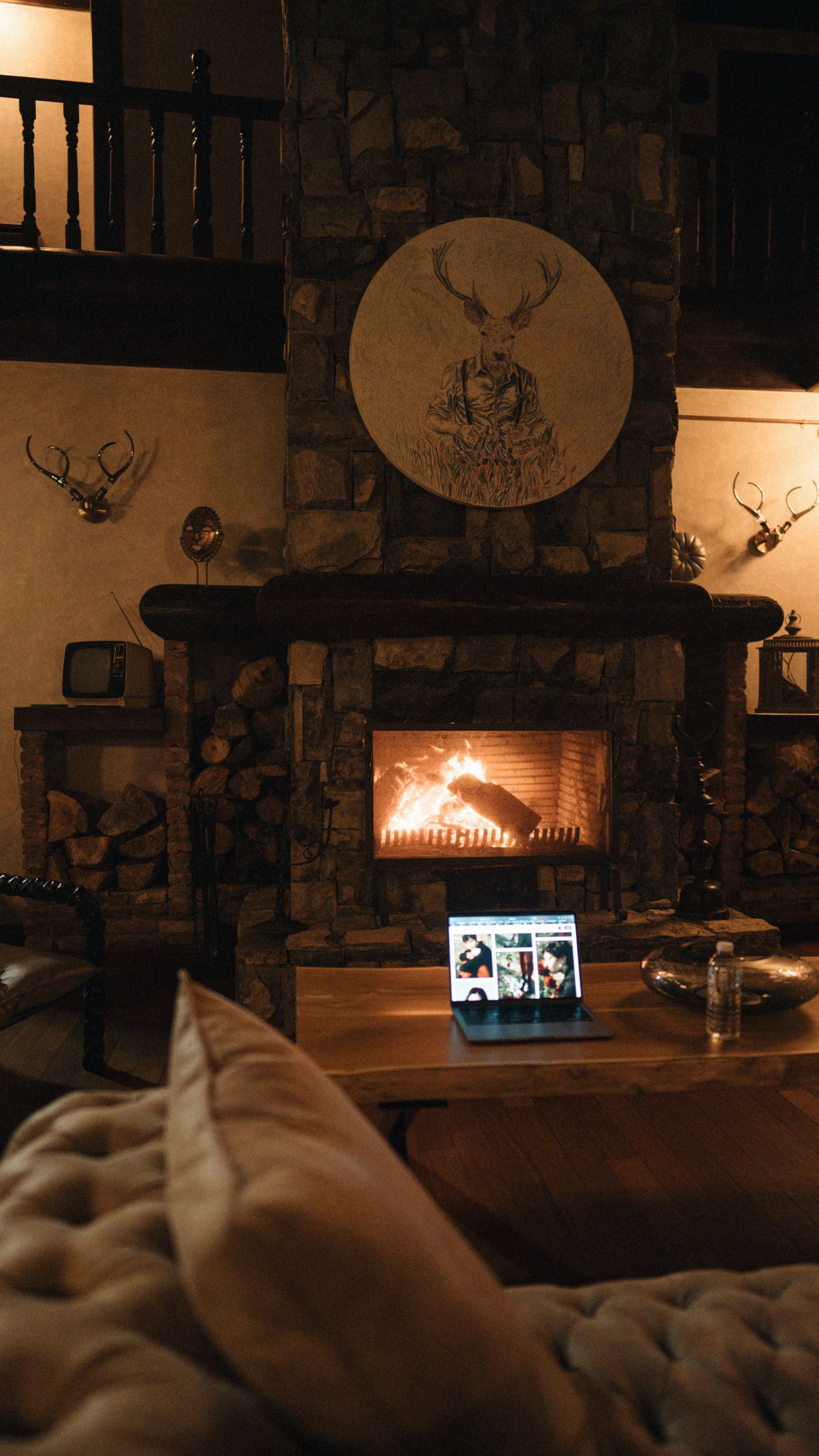 Salon chaleureux avec cheminée allumée dans un gîte à la campagne, l'endroit idéal pour brancher une box 5G pendant les vacances de la Toussaint