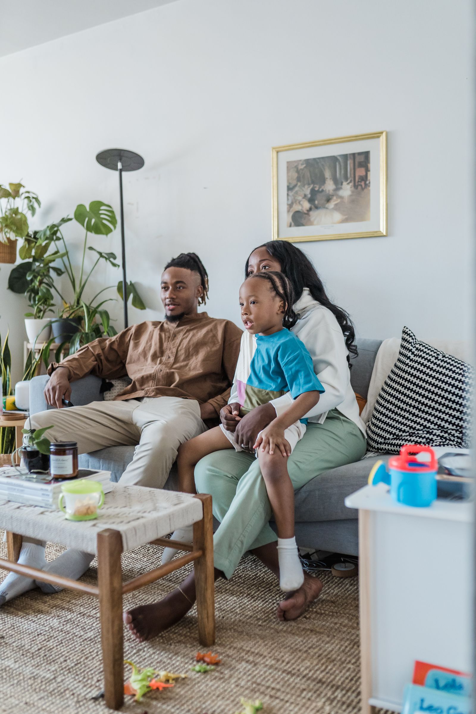 Famille installée sur le canapé du salon devant la télévision, connectée en Wi-Fi grâce à une box 5G