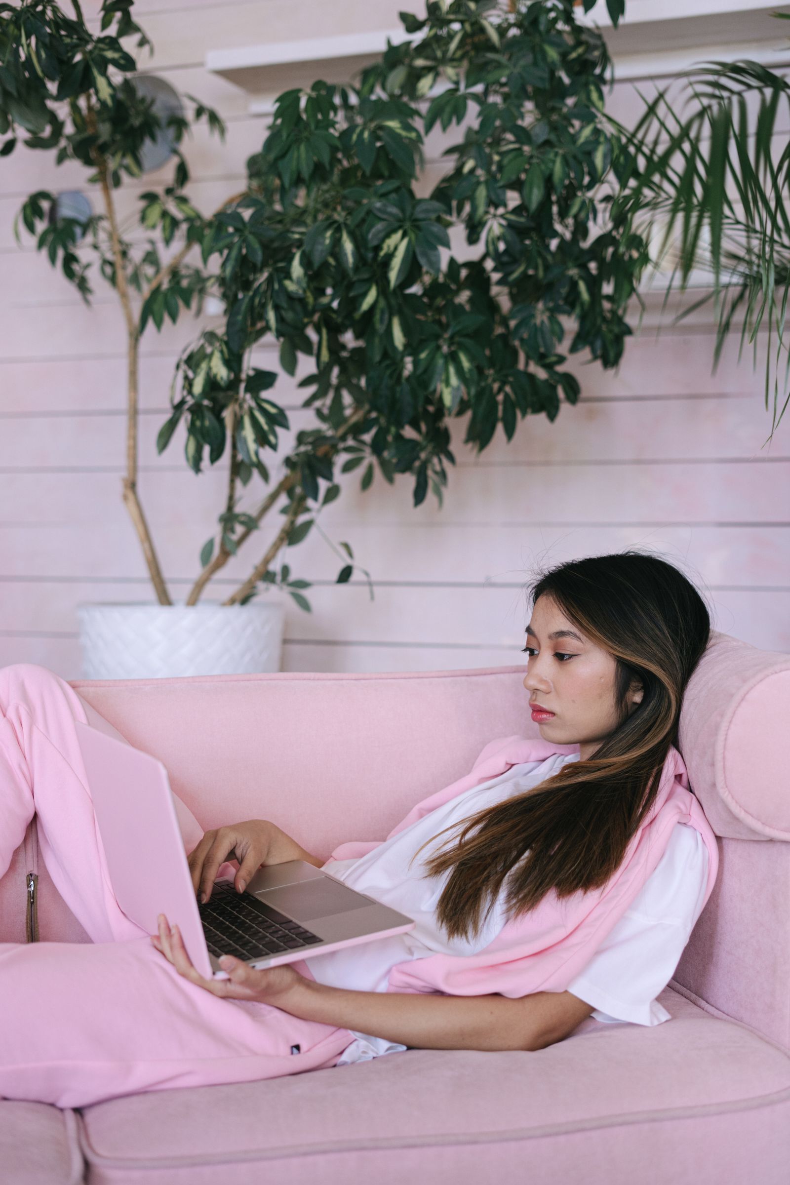 Femme allongée sur un canapé qui télécharge des mises à jour sur son ordinateur portable avec une connexion box 5G