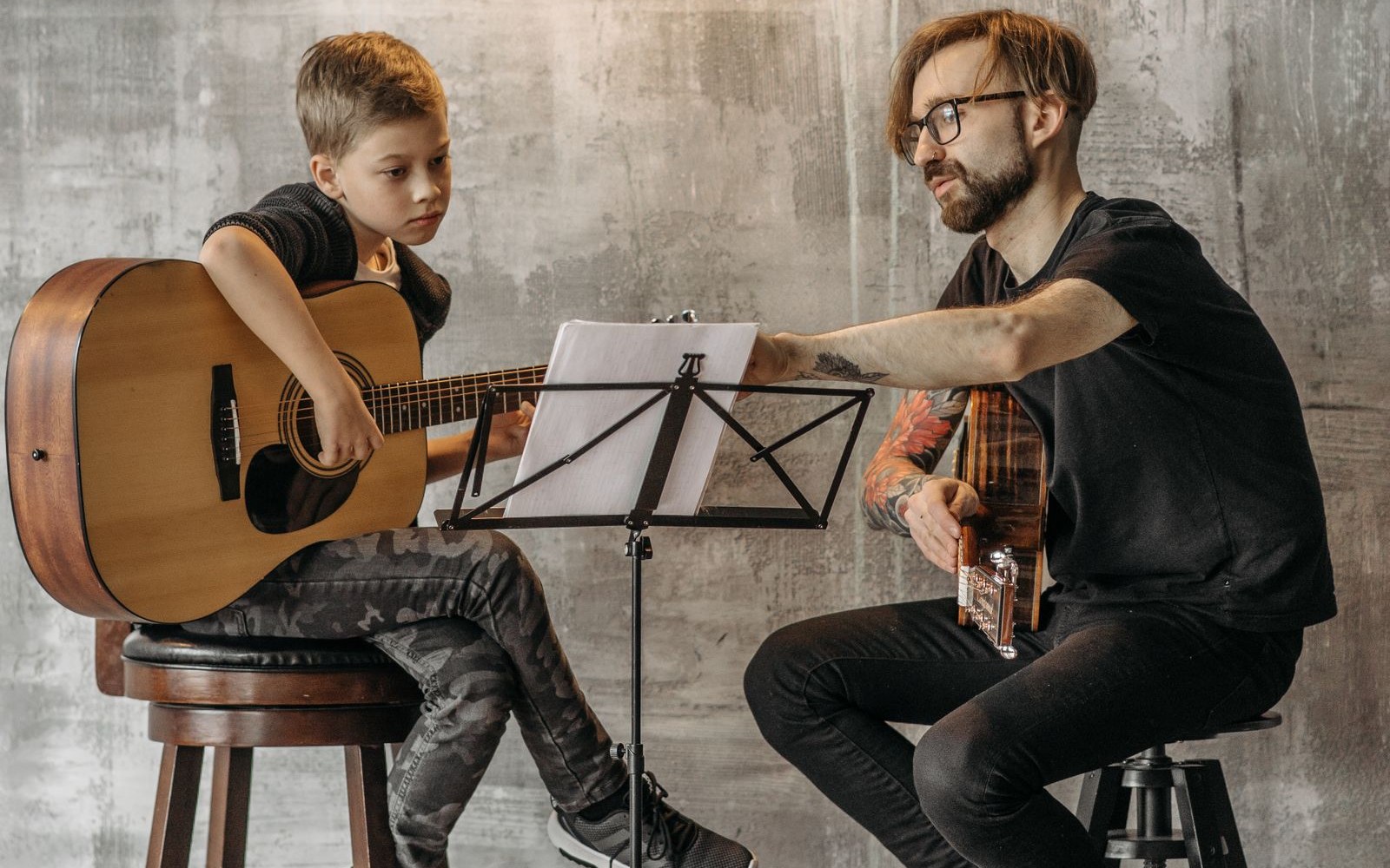 Élève qui suit un cours de guitare avec son professeur : une connexion stable pour des cours de musique en visio sans fibre