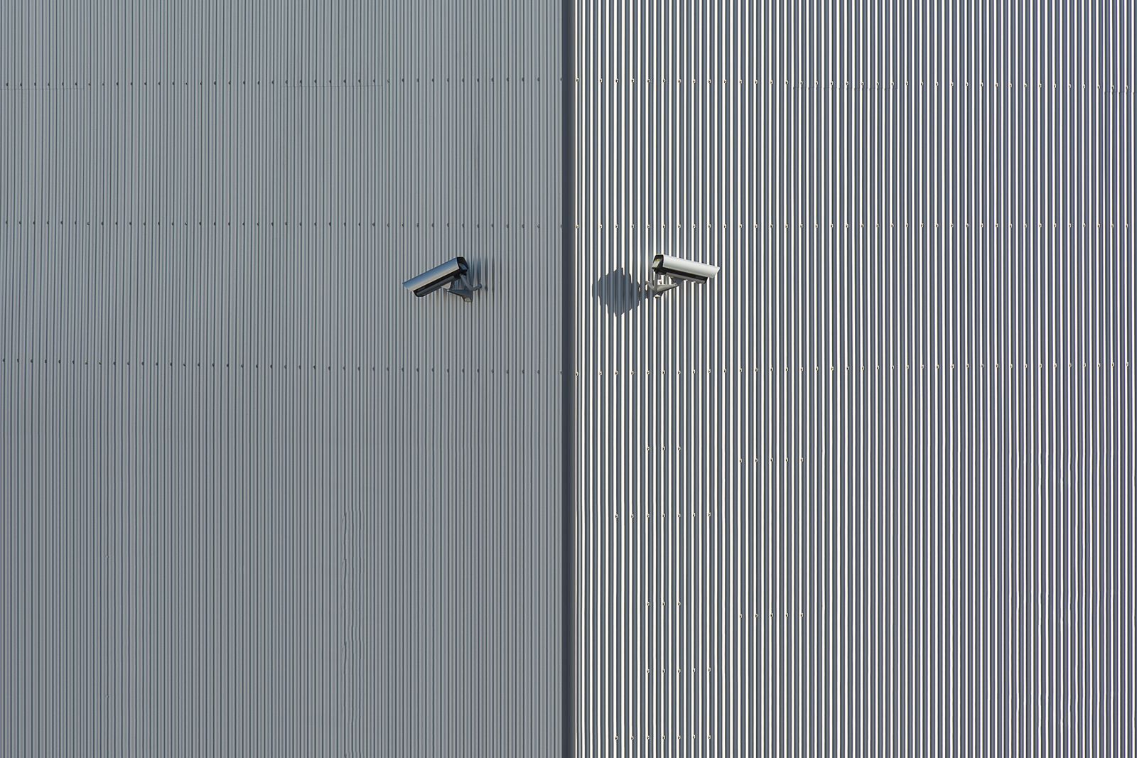 Deux caméras de vidéosurveillance fixées sur le bardage métallique d'un site professionnel connecté sans fibre