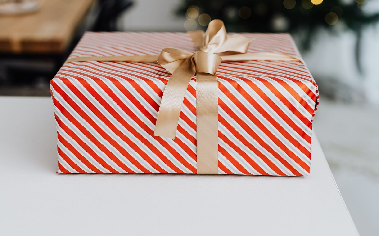 Cadeau de Noël emballé avec ruban doré, idéal pour offrir une box internet 5G à ses parents