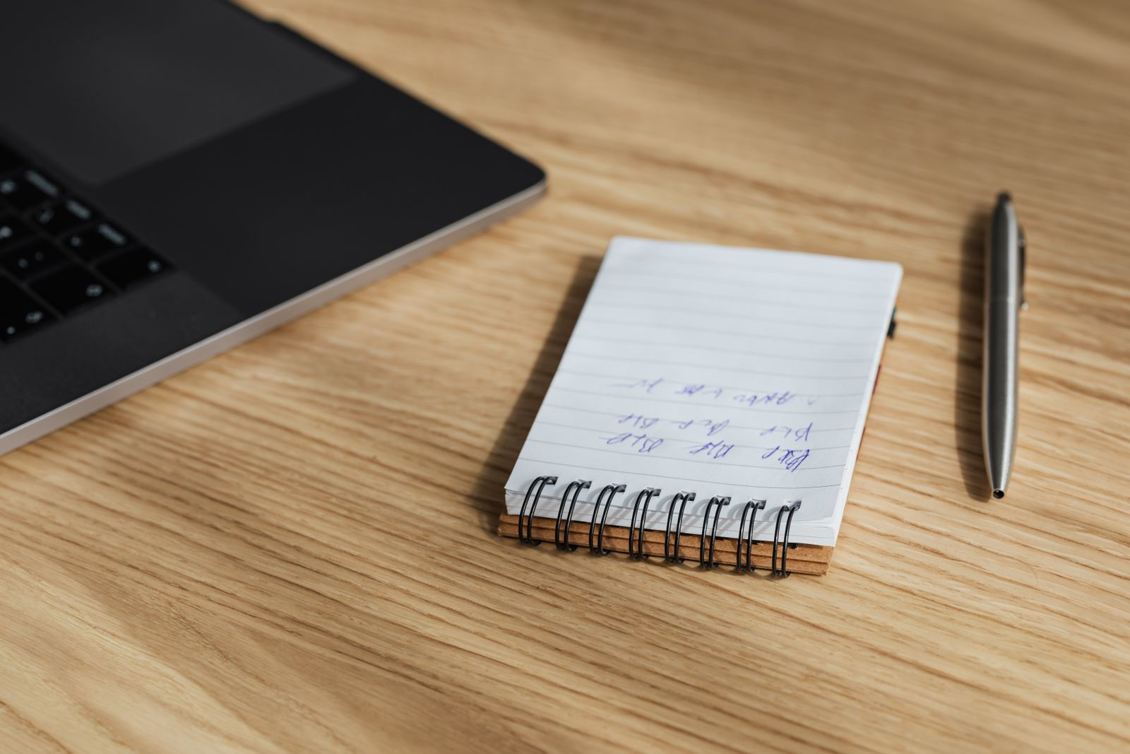 Bureau de traducteur indépendant avec ordinateur portable, carnet de notes et stylo sur une table en bois